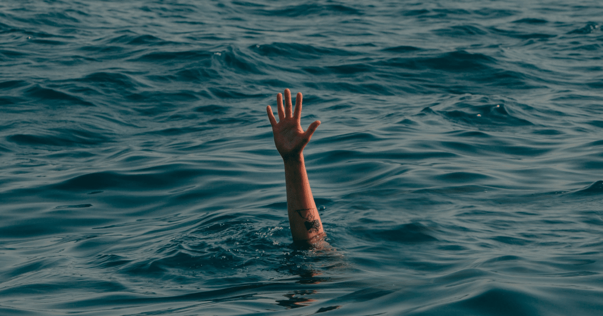 JULY-BLOG IMAGES 4 - San Jose Mental Health Raised arm emerging from rough blue ocean, suggesting someone in distress and calling for help.
