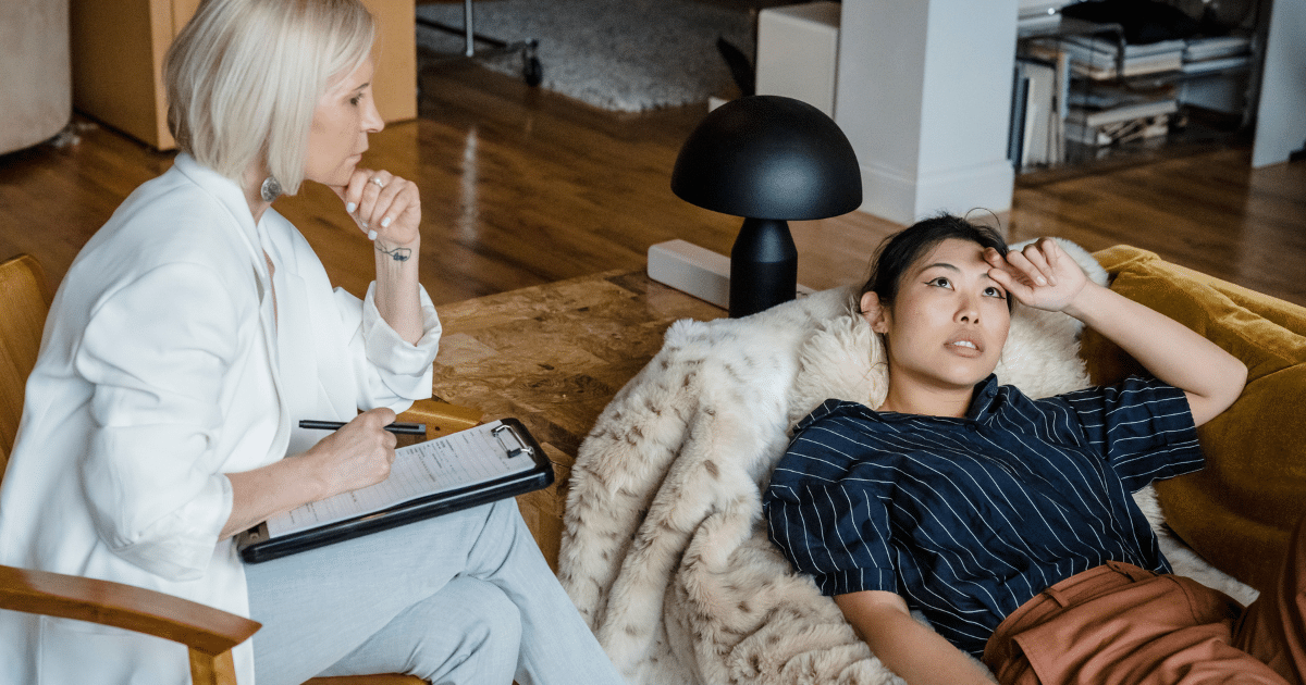 August-Blog Images 4 - San Jose Mental Health Therapist taking notes on a clipboard as a client rests on a plush fur blanket in a cozy living room setting.